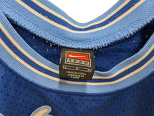 Load image into Gallery viewer, Close-up of a blue sports jersey with a Nike Team label.
